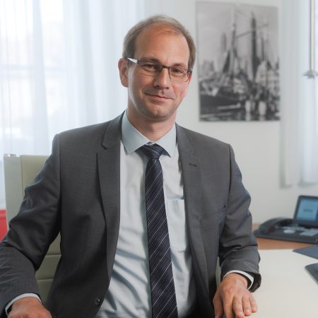 Nachfolger Christian Benke sitzt im Büro der Benke Steuerberatung und blickt freundlich in die Kamera.